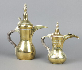 An engraved brass Arabic Dallah coffee pot with crescent mark 22cm x 7cm together with a plain ditto with heart shaped mark 30cm x 10cm 