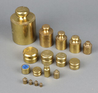 Ten various brass bell weights - 5kg, 1000mrg, 500mrg (x2), 200mrg, 50grams, 20grams, 10grams (x2), 5grams, 7 various brass money weights - ten pound fifty pences, five pounds silver, one pound bronze, one pound one hundred notes, one hundred five pound notes, fifty pence bronze, 25 pence bronze  