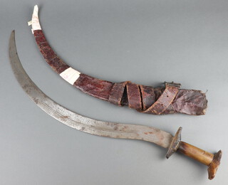 An African sword with wood grip contained in a leather scabbard 79cm