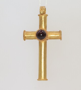 A Roman style yellow metal cross pendant set with a cabochon cut garnet 8.1 grams, 60mm x 30mm  