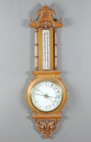 A Barrett & Russell of Leeds Victorian aneroid barometer and thermometer with porcelain dial, contained in a carved oak wheel case, the dial marked patent number 12001 90cm h x 29cm w
