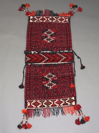 A red, black and white ground Afghan saddle bag 111cm x 54cm 
