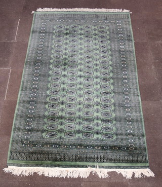 A green and black ground Bokhara rug with 78 octagons to the centre within a multi row border 258cm x 157cm 