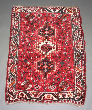 A red, blue and black ground Afghan rug with 3 stylised medallions to the centre 153cm x 107cm 