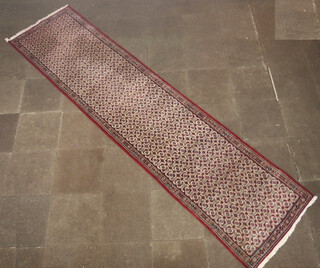 A red, white and blue ground Persian runner, floral patterned within a multi row border 406cm x 98cm  