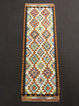 A yellow, white and black ground Chobi Kilim runner with diamond decoration to the centre 196cm x 61cm 