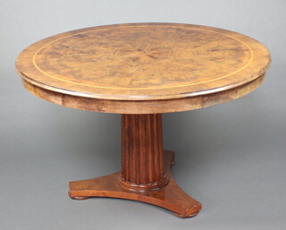 A Georgian style figured walnut and crossbanded pedestal dining table raised on a turned and fluted column with triform base 132cm diam.  
