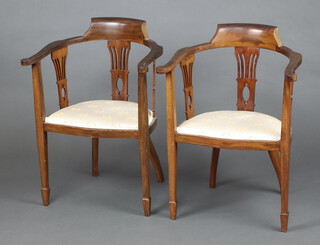 A pair of Edwardian beech framed tub back chairs with splat back decoration, the seats of serpentine outline raised on square supports, spade feet 83cm h x 60cm w x 40cm d (seats 32cm x 30cm) 
