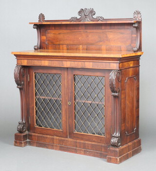 A William IV rosewood chiffonier, the raised back fitted a shelf, the base enclosed by glazed and grilled panelled doors, having scrolled columns to the sides 131cm h x 117cm w x 44cm d 