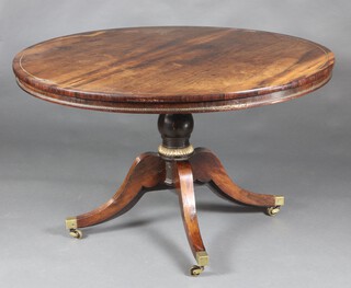 A Regency rosewood, inlaid brass circular breakfast table, raised on a turned column and tripod base ending in brass caps and casters 72cm h x 122cm diam.  
