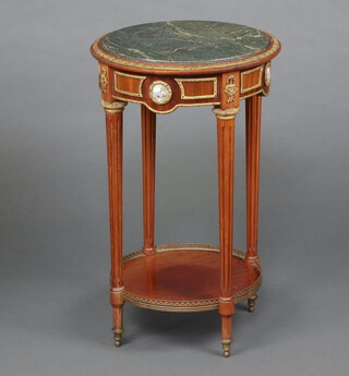 A circular mahogany Empire style occasional table with green veined marble top, gilt metal mounts and porcelain plaques to the apron, raised on turned and fluted supports with galleried undertier 74cm h x 46cm diam. 