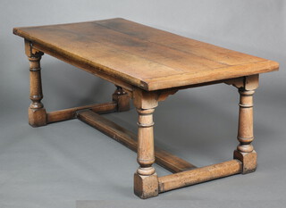 A 17th Century style oak refectory dining table, the top formed of 3 planks raised on turned and block supports with H framed stretcher 73cm h x 197cm w x 90cm d 
