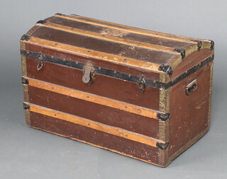 A 19th Century wooden and fibre bound domed cabin trunk with hinged lid, applied various luggage labels, 56cm h x 86cm w x 48cm d  