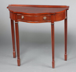 A Georgian style crossbanded mahogany side table of serpentine outline with raised back fitted a drawer, raised on square fluted supports 76cm h x 82cm w x 36cm d 
