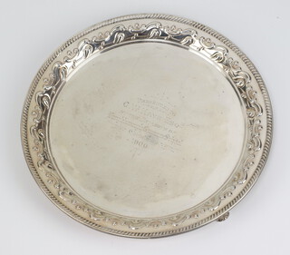 A Victorian circular silver repousse salver raised on scroll feet with engraved inscription, Sheffield 1897, 26cm, 547 grams 