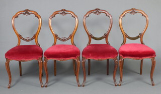 A set of 4 Victorian carved walnut balloon back dining chairs with over stuffed seats, raised on cabriole supports 90cm h x 44cm w x 38cm d (seats 24cm x 24cm)