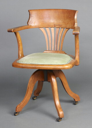 An Edwardian light oak tub back revolving office chair with pierced vase shaped slat back 81cm h x 62cm w x 45cm d (seat 30cm x 27cm) 