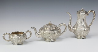 A fine 19th Century Chinese white metal repousse tea set comprising teapot, coffee pot and sugar bowl, having bamboo effect handles, profusely decorated with heron, carp, dragons, monkeys, insects, seaweed, shells, bamboo, peony and chrysanthemum, raised on floral scroll feet, gross weight 1579 grams. Exemption Certificate Y34F9ZLF