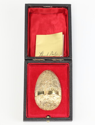 A Stuart Devlin silver gilt egg numbered 22 of 300, with bright cut exterior decoration, the enamelled interior containing an articulated frog on a lily pad, London 1978, with original box, 183.7 grams, 7cm 