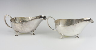 A pair of silver Arts and Crafts hammer pattern sauce boat on pad feet, Birmingham 1925, maker A E Jones, 17cm, 313 grams 
