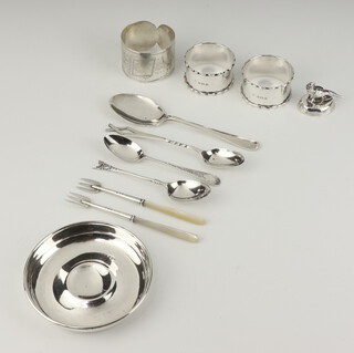 A silver pin tray London 1921, 4 spoons, 3 napkin rings, 2 mother of pearl handled forks and a menu holder, gross weight 190 grams 