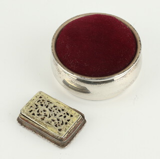 A circular silver pin cushion Birmingham 1989 and the base of a 19th Century silver vinaigrette.