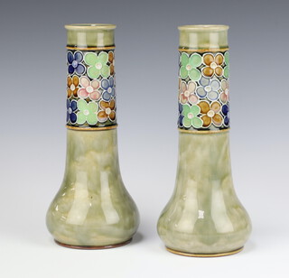 A pair of Royal Doulton green salt glazed vases decorated with a band of stylised floral heads, bases impressed 7786 Royal Doulton 25cm