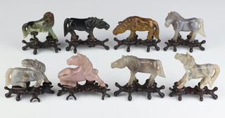 A set of 8 Chinese carved hardstone figures of horses raised on hardwood stands 7cm 