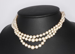 A triple strand of cultured pearls with a white metal diamond clasp 34cm 