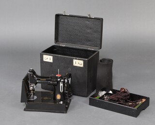A 1951 Singer Featherweight electric sewing machine complete with foot control, bobbins, etc and foot mat, cased 