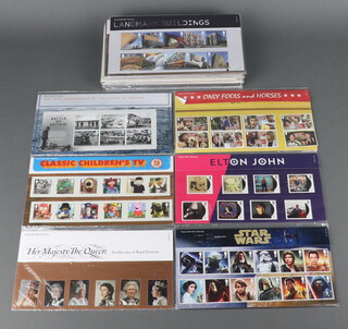 31 various GB Elizabeth II presentation stamp sets including James Bond, Star Wars, Children's TV Shows etc