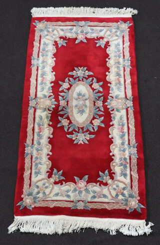 A red and white ground floral patterned Chinese rug 186cm x 89cm 