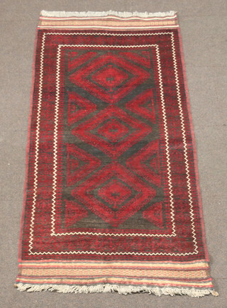 A red and black ground Belouche rug with 3 diamond shaped medallions to the centre within a multi row border 210cm x 102cm 