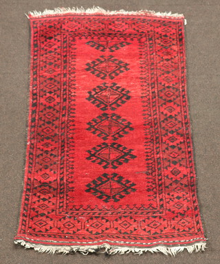 A red and black ground Afghan rug with 5 octagons to the centre 143cm x 84cm 