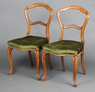A pair of Victorian bleached mahogany balloon back dining chairs with shaped mid rails and overstuffed seats  of serpentine outline, raised on cabriole supports 86cm h x 45cm w x 40cm d (seat 25cm x 27cm)