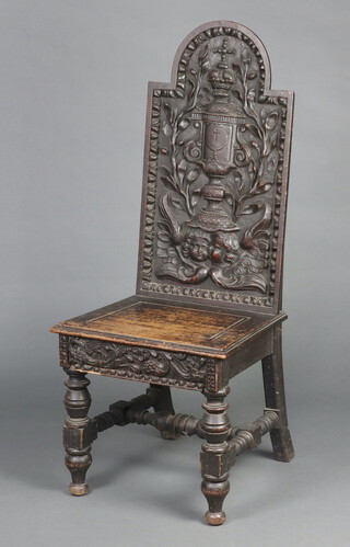 A 19th Century  Continental deeply carved oak hall chair, the back carved a cross with challis above angels, raised on turned and block supports 118cm h x 50cm w x 41cm d (seat 26cm x 30cm) 