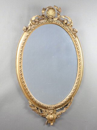 A 19th Century oval plate mirror contained in a decorative gilt frame surmounted by a shell 101cm h x 59cm w