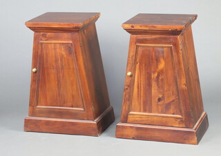 A pair of Regency style triangular shaped bedside cabinets enclosed by panelled doors, on platform bases 79cm h x 40cm w x 41cm d 