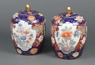 A pair of Japanese style Imari urns and covers with panelled decoration 33cm h 
