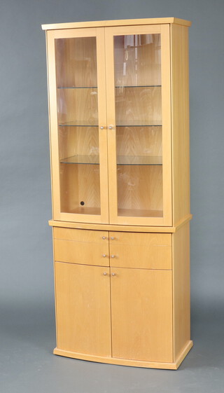 Skovby, a beech bow front display cabinet fitted shelves enclosed by panelled doors, base fitted 2 long drawers above a cupboard enclosed by a pair of panelled doors 206cm h x 82cm w x 45cm d 