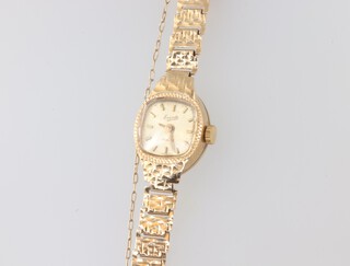 A lady's Evite wristwatch contained in a 9ct gold case with integral bracelet, 8.8 grams including a charm  