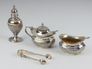 An Edwardian 3 piece silver condiment set with demi-reeded decoration - salt, pepper and mustard pot (with blue glass liner)  London 1906 and 1907 together with 2 condiment spoons and a pair of silver tongs, 139 grams 