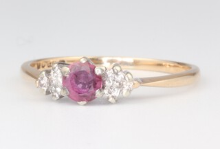 A 9ct yellow and white gold ruby and diamond set ring, the central ruby approx. 0.3ct, supported by 6 diamonds each approx 0.01ct, 1.9 grams