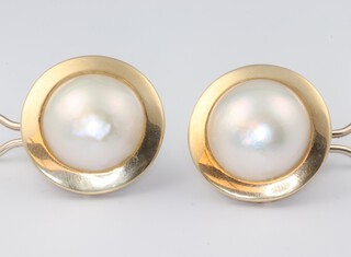A pair of yellow metal marked 750 and large Mabe pearl earrings, the pearls set in a flat circular surround with post and spring fitting, 24mm diam., gross weight 15.6 grams 