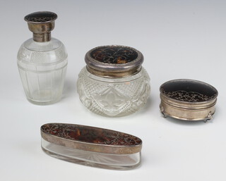 A circular cut glass dressing table jar with silver and tortoiseshell lid, London (marks rubbed) 9cm, a silver and tortoiseshell scent bottle with hinged lid and stopper 14cm (chips to stopper, lid dented), ditto oval pin jar with silver and tortoiseshell lid (marks rubbed), ditto trinket box 8cm (pin to lid a/f)  