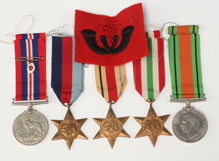 A group of Second World War medals comprising 1939-45 Star, Africa Star, Italy Star, Defence and War medal  together with a Divisional badge 