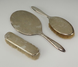 A silver handled clothes brush Birmingham 1917 together with a Sterling silver backed hand mirror and matching clothes brush  