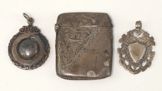 A silver vesta case with engine turned decoration together with 2 silver sports fobs 