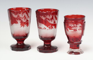 A Bohemian etched red glass goblet with panels decorated stags and hound 12cm (light chips to rim) together with a pair of panel cut goblets decorated stags 13cm (1 has large chip to rim, 1 has a small chip to rim) 