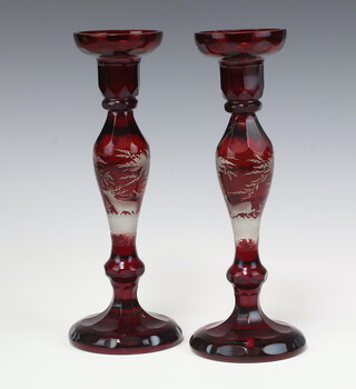 A pair of Bohemian red overlay glass candlesticks decorated stags 28cm 